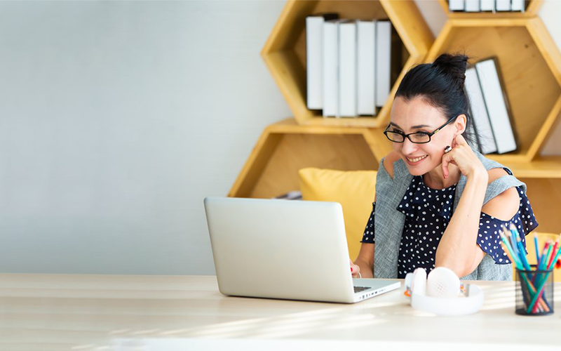 Woman on computer with bookshelves